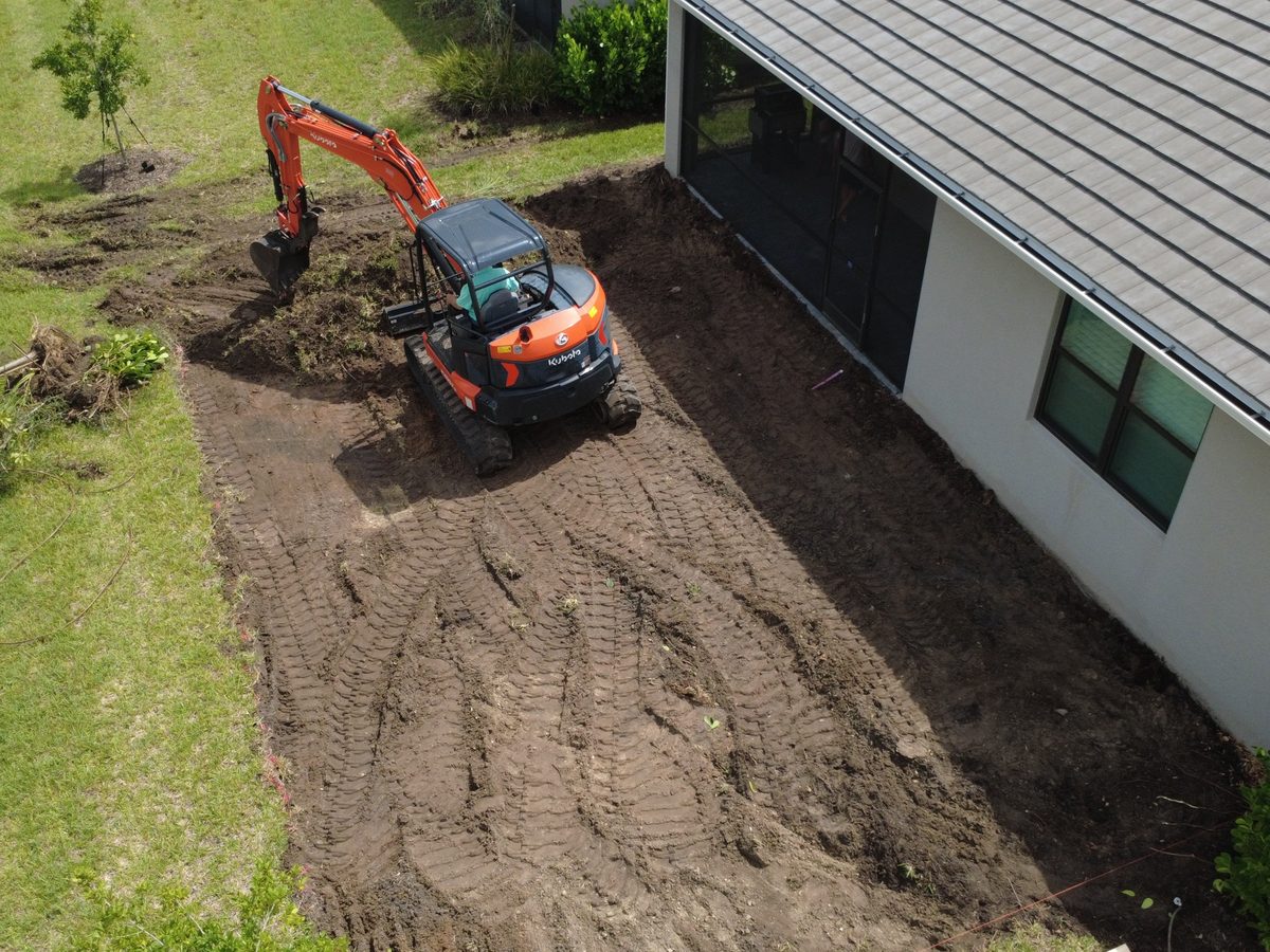 Kubota mini excavator grading alongside a home in Sarasota County