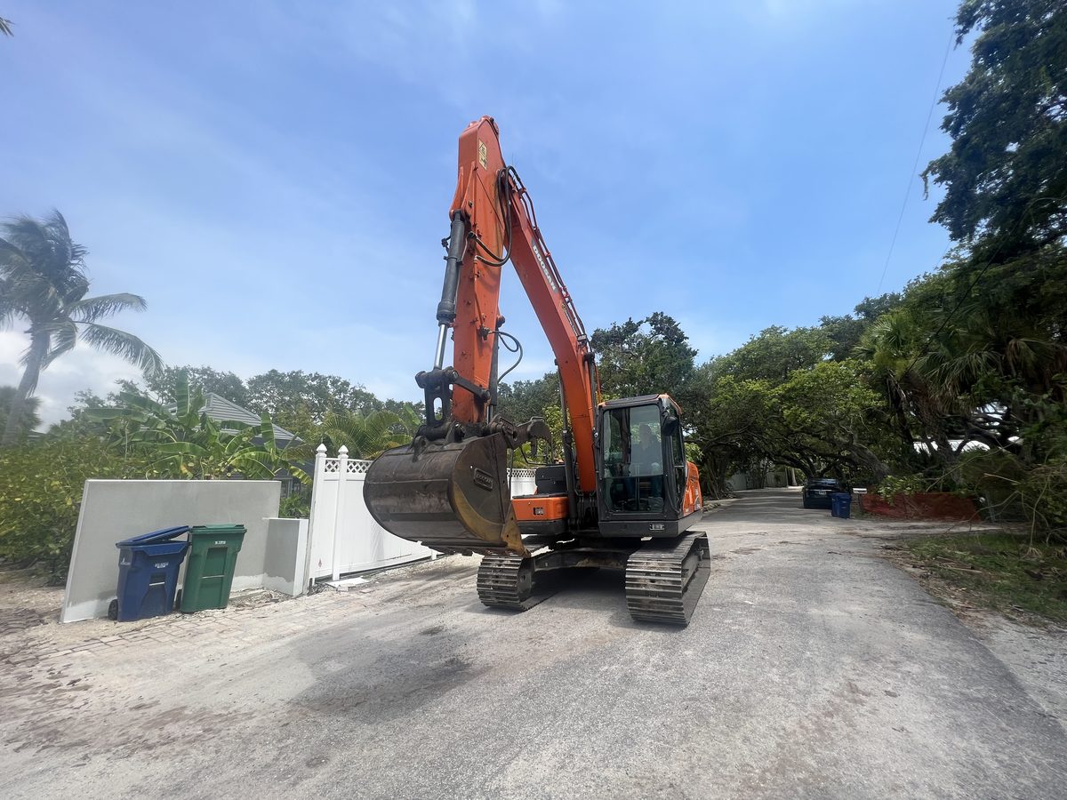 Residential excavator work — Doosan excavator on a driveway preparing for site work