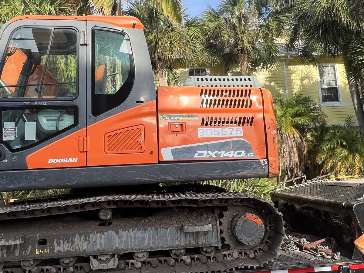 Equipment mobilization — Doosan DX140LC loaded on a Landoll trailer ready for transport